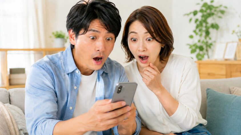 口コミ33件と総合評価を確認。リビングでスマホを見る夫婦2人が驚いた表情