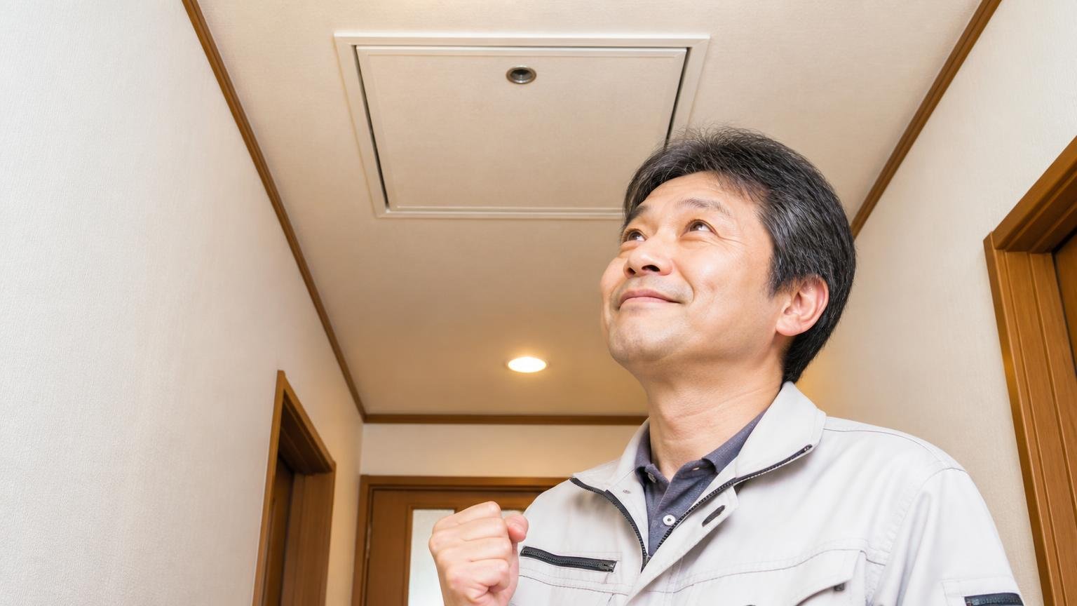 フンが止まり足音が消えた声 木造戸建ての天井裏点検口を見上げる廊下で50代男性が安堵の笑顔