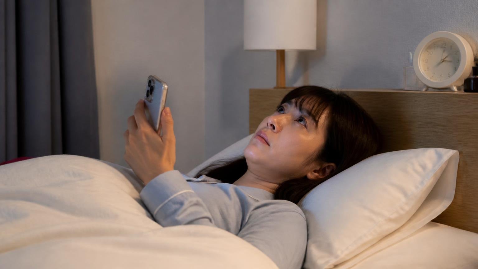 手がかり①何時に鳴るか。深夜の寝室で女性1人が枕元のスマホで時刻を確認し天井を見上げる