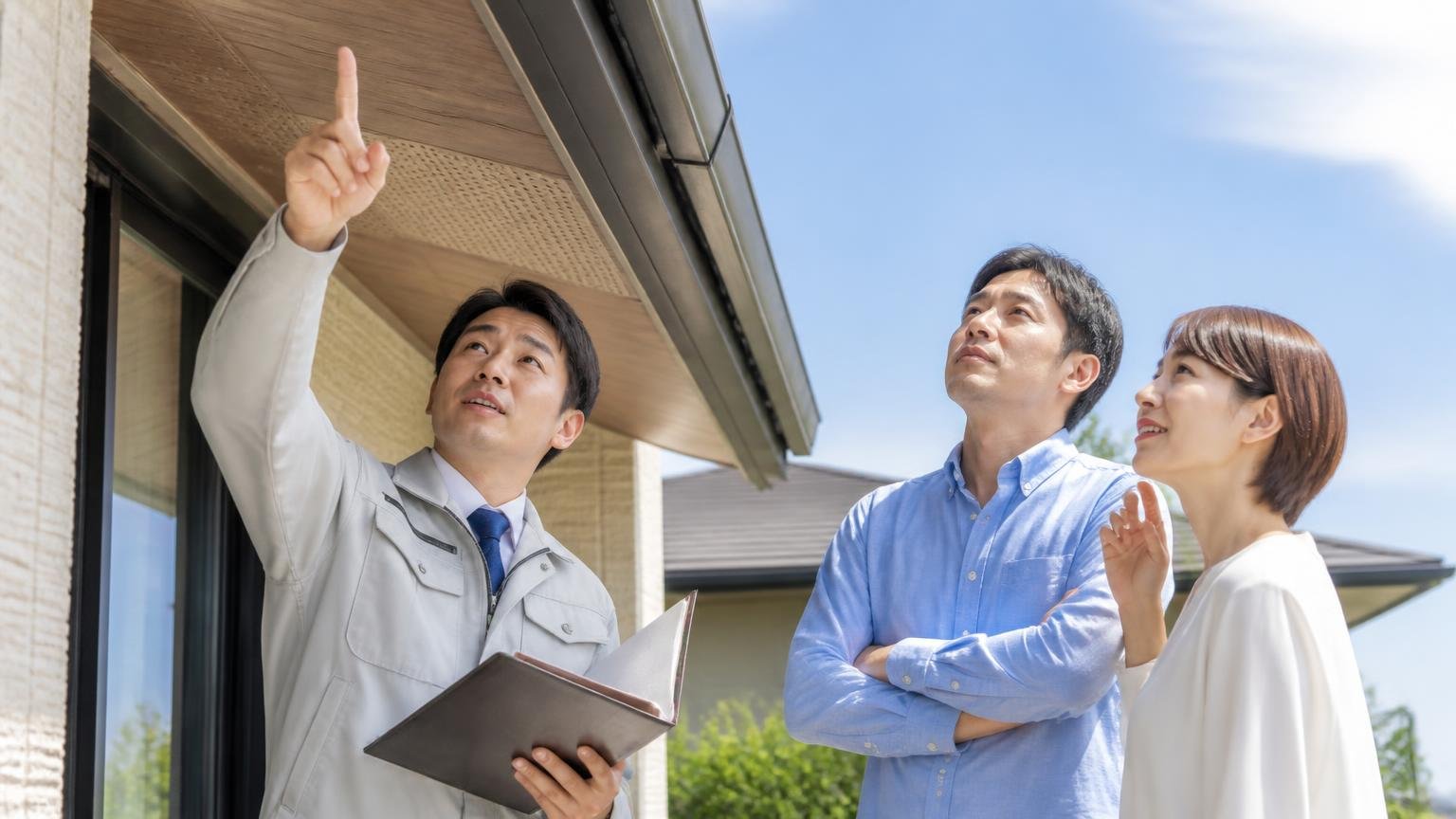 何社も見積もりを取ってようやく納得できる1社に出会えた。家の軒下を見上げて業者と話す夫婦2人