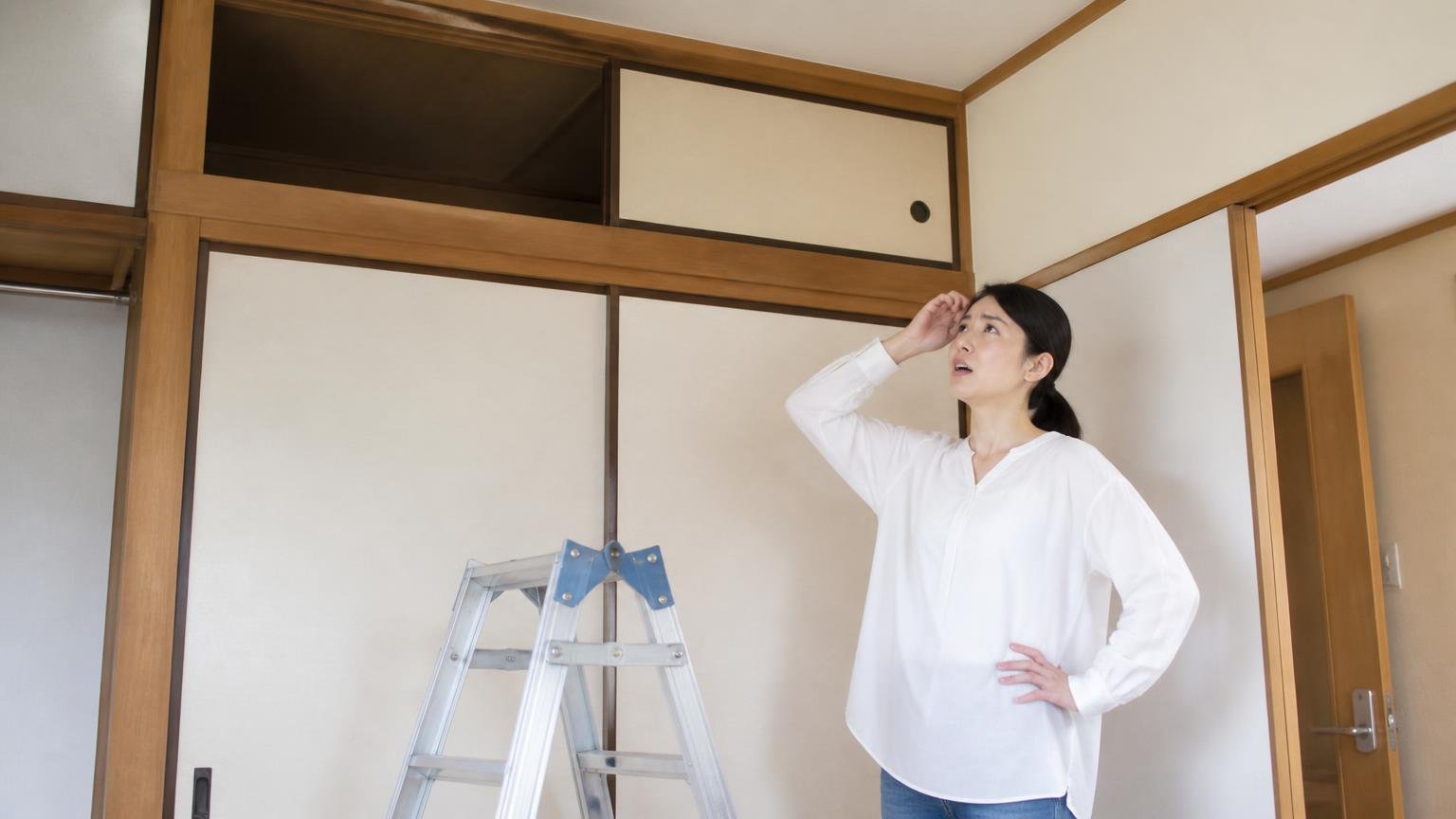 天井裏の点検口が開けられず困る場面 木造戸建ての押し入れ前で天袋を見上げる30代女性1人 脚立の前で立ち尽くす