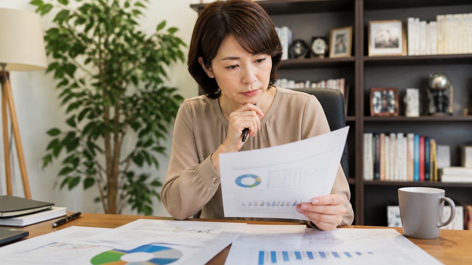 調査結果の読み方 書斎で女性1人が資料を手に取り確認する