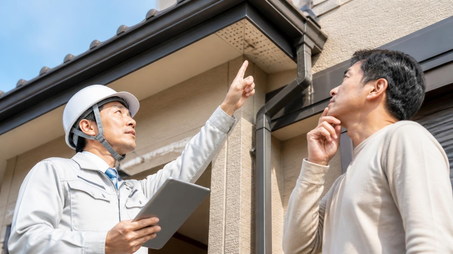 プロでないと難しい3つの領域|住宅の屋根の軒下を見上げて調査する作業員と住人の2人
