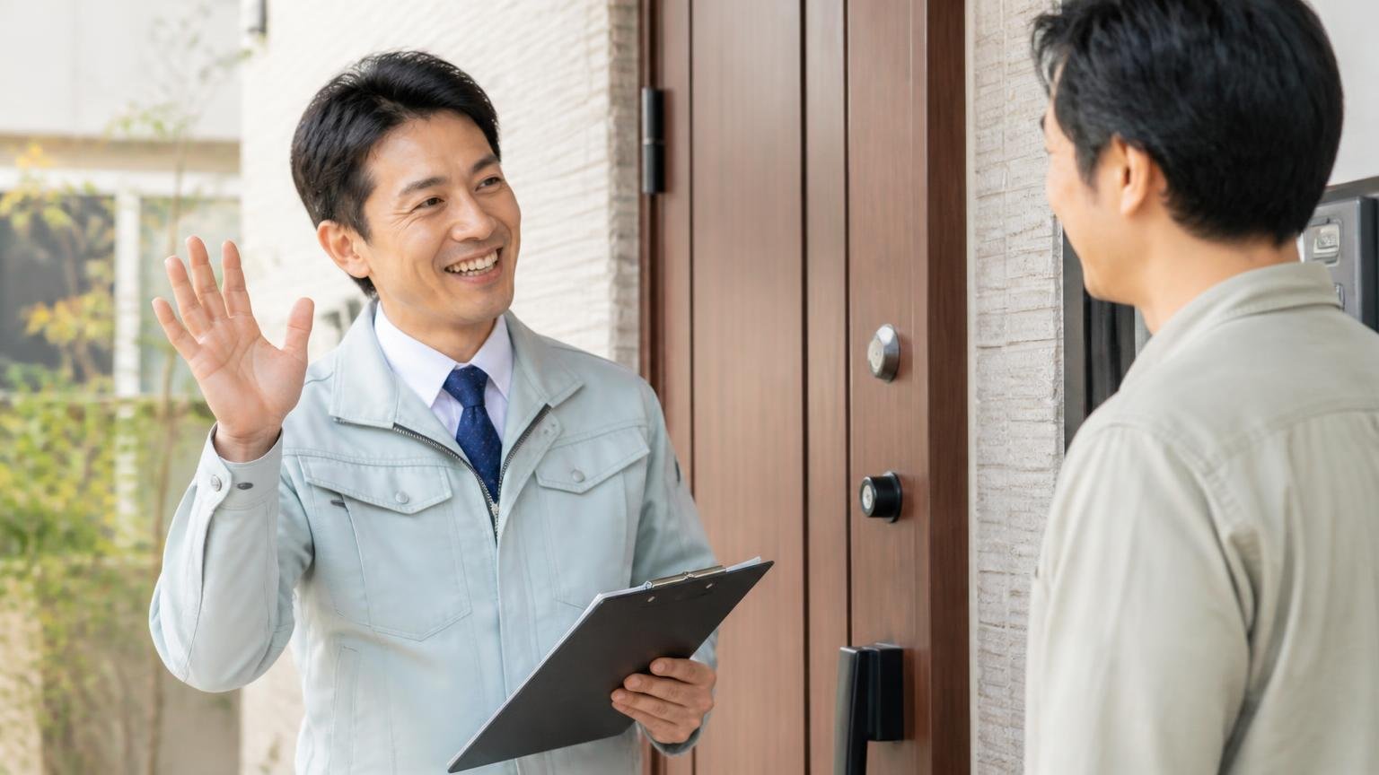 相見積もりの1社目を選ぶ。住宅の玄関前で作業員1人が住人男性1人に笑顔で挨拶する