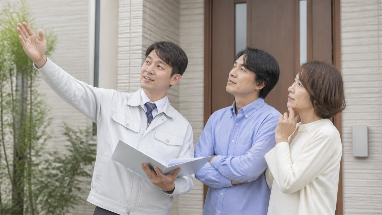 一個だけの段階で無料調査を受けると得をする理由|住宅の玄関前で作業員を迎える住人と説明を聞く2人