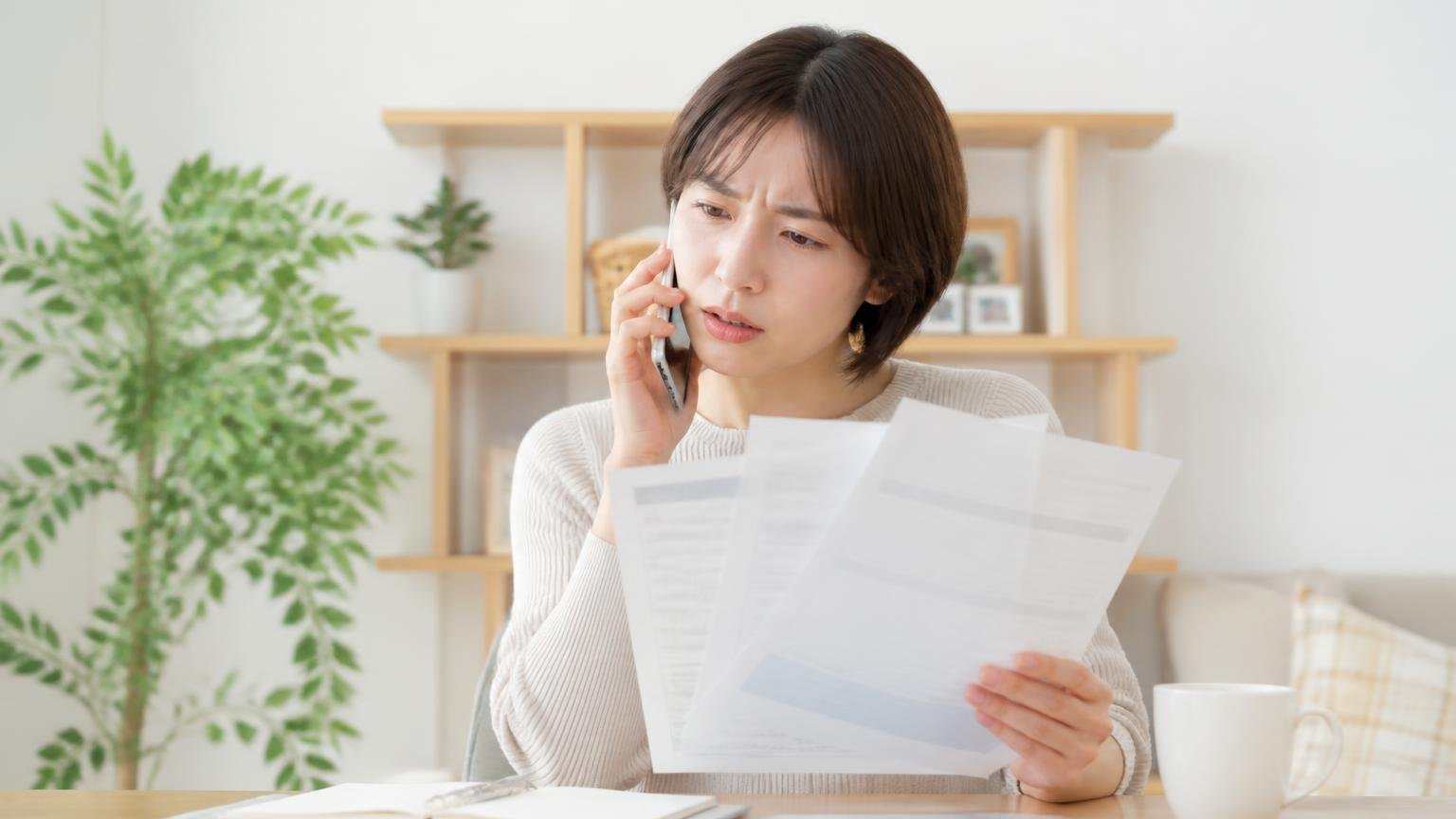 相見積もりで聞きたい五つの質問。スマホを片手に複数社へ電話をかける30代女性1人